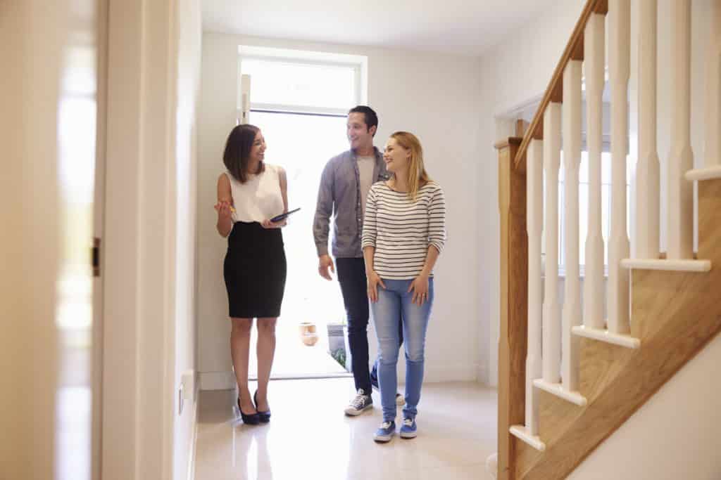 Real estate agent showing a house. Source: https://www.shutterstock.com/image-photo/realtor-showing-young-family-around-property-451242226