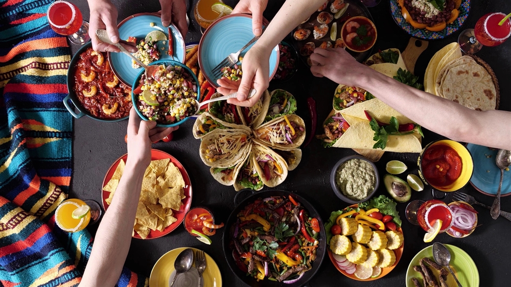 Best places for tacos and best taco cities in America concept. Group of people enjoying a table of tacos and other side dishes.